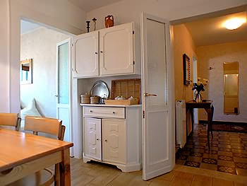 To the right of the dresser the entrance and to the left the access to the living room