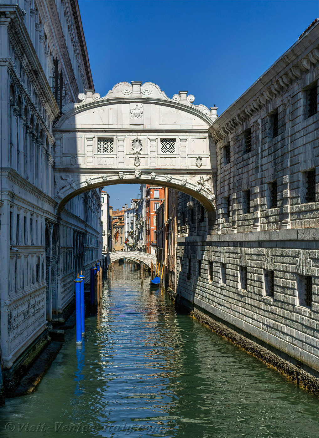 Doge's Palace and the Bridge of Sighs in Venice, Italy, viewed from a canal with historic architecture.